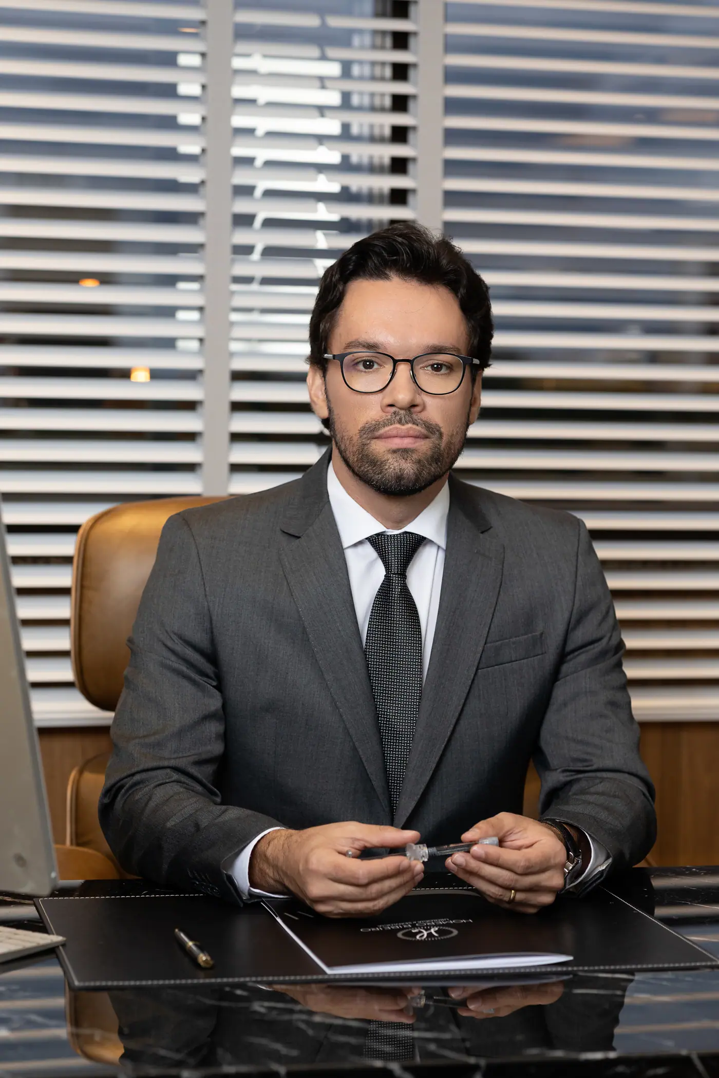 Dr. Homero Ribeiro à mesa do consultório de urologia e andrologia em Brasília